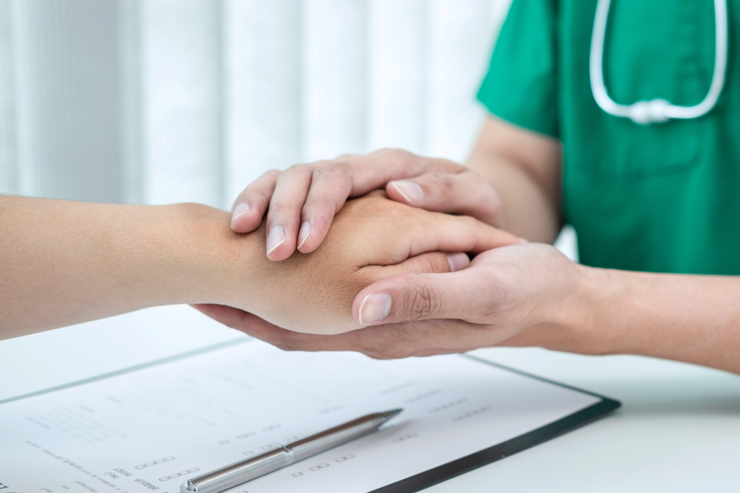 Hand of doctor touching patient reassuring for encouragement and