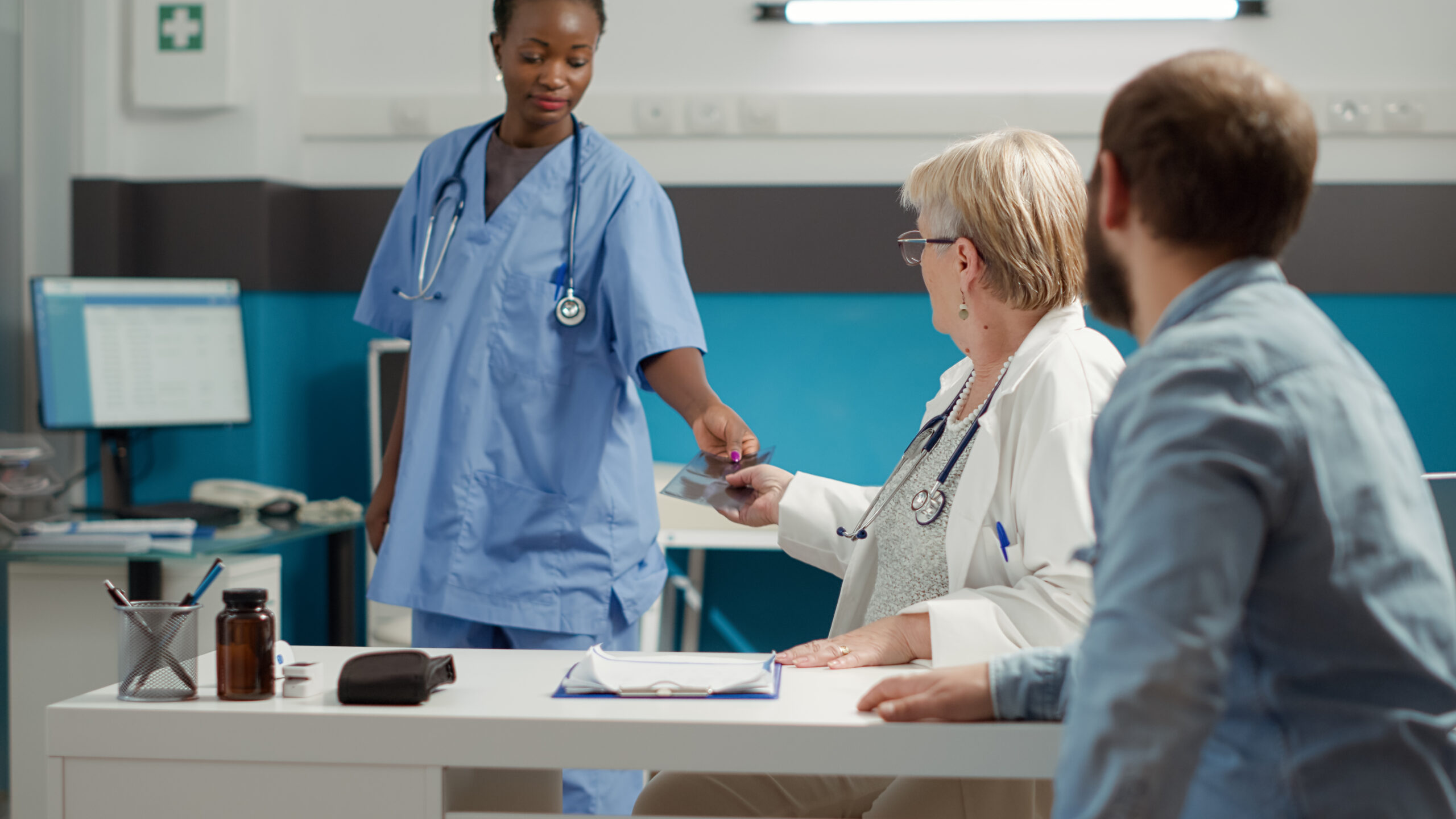 Senior physician showing x ray bones scan to sick patient